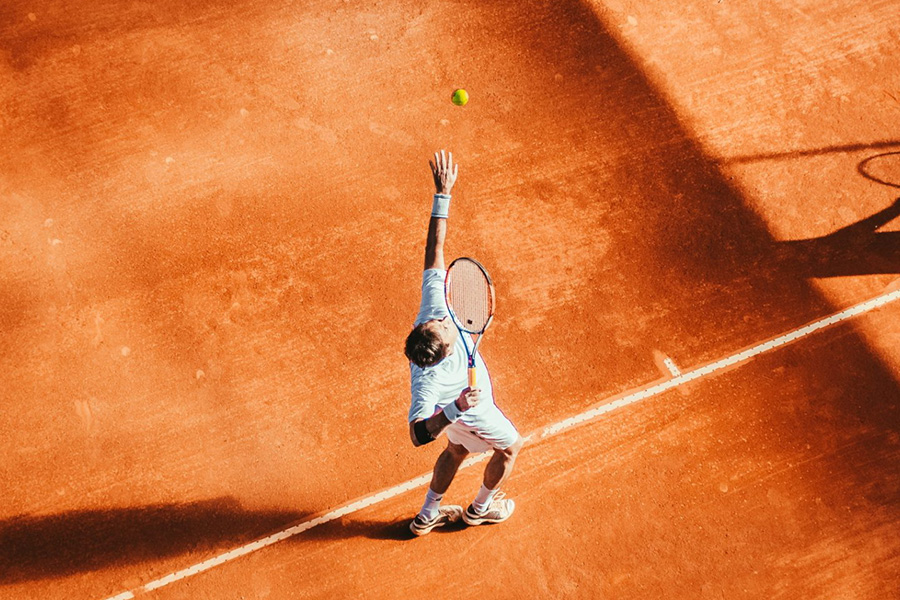 man serving tennis ball