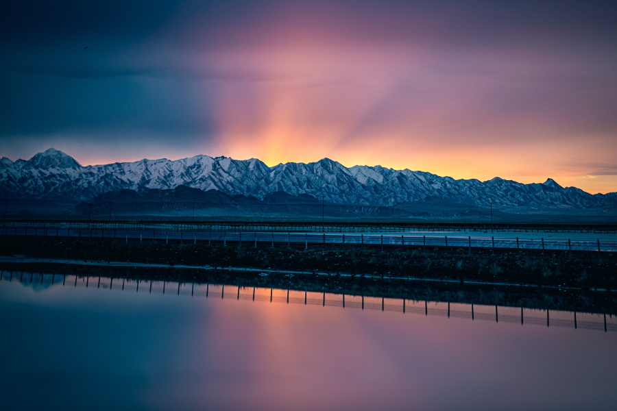 sun rising over mountain ridge and lake